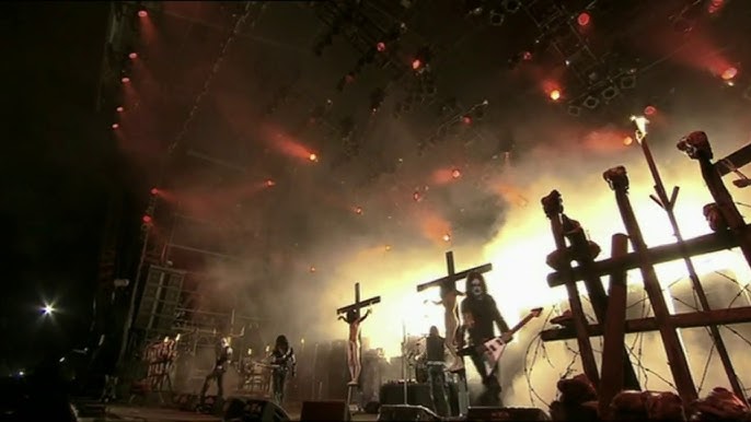 Presentación de God Seed en WOA con crucifixión y símbolos religiosos